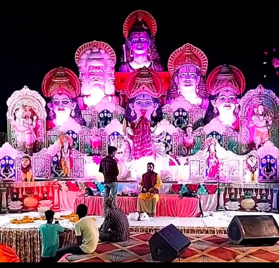 Festive devotional stage with deity statues and flowers